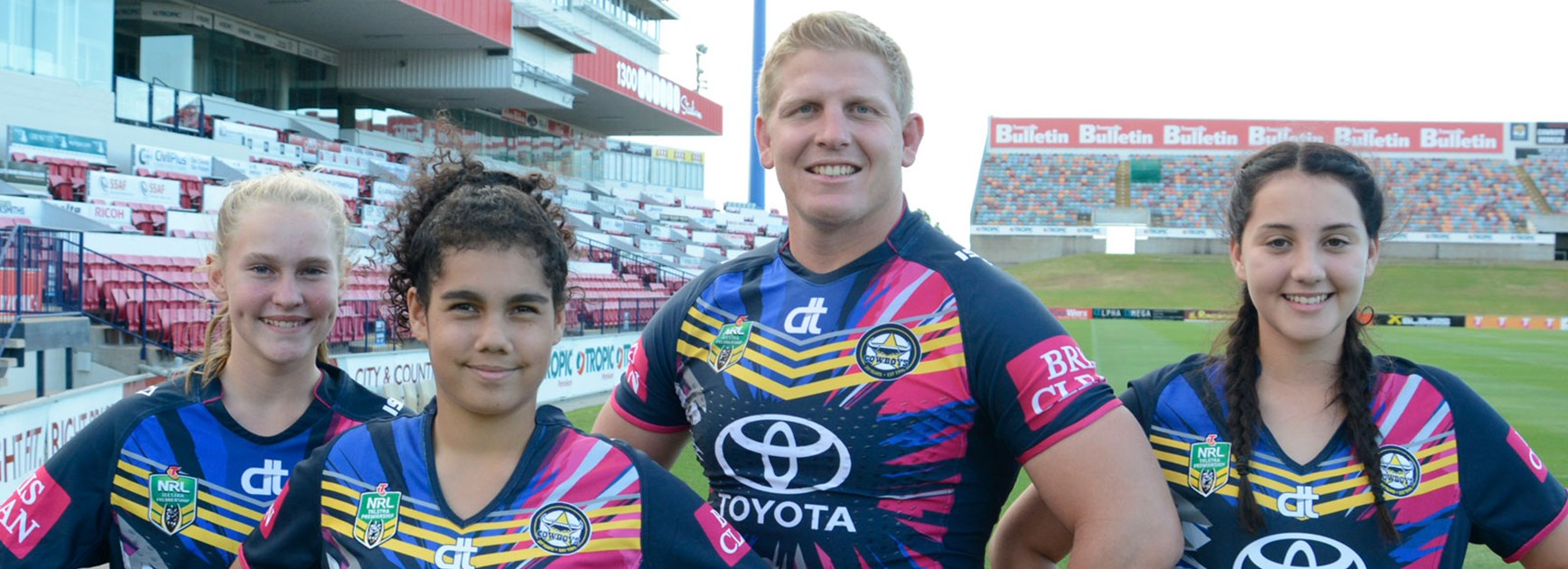 Prop Ben Hannant models the Cowboys' Women in League jersey along with Townsville under-14 players Erin Tremblett, Izabella Kennedy and Maddison Craigie.