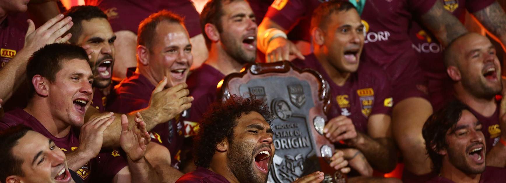 Maroons players celebrate with the Origin shield.