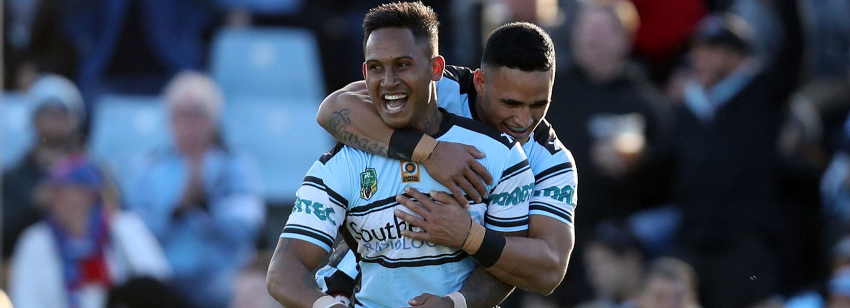 Ben Barba and Valentine Holmes celebrate during the Sharks' win over the Knights.