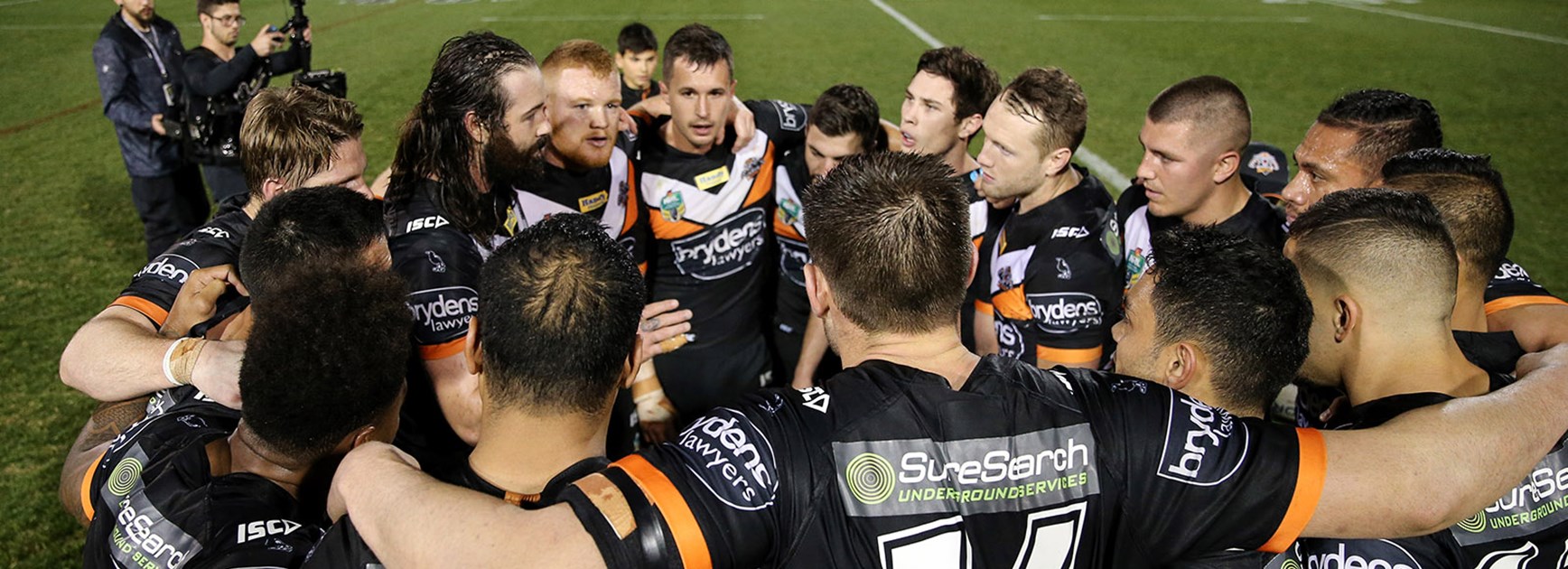 Wests Tigers huddle after upsetting the Cowboys at Leichhardt Oval.