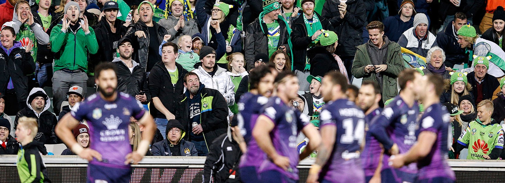 Storm look on dejected as Canberra fans celebrate at a packed GIO Stadium.