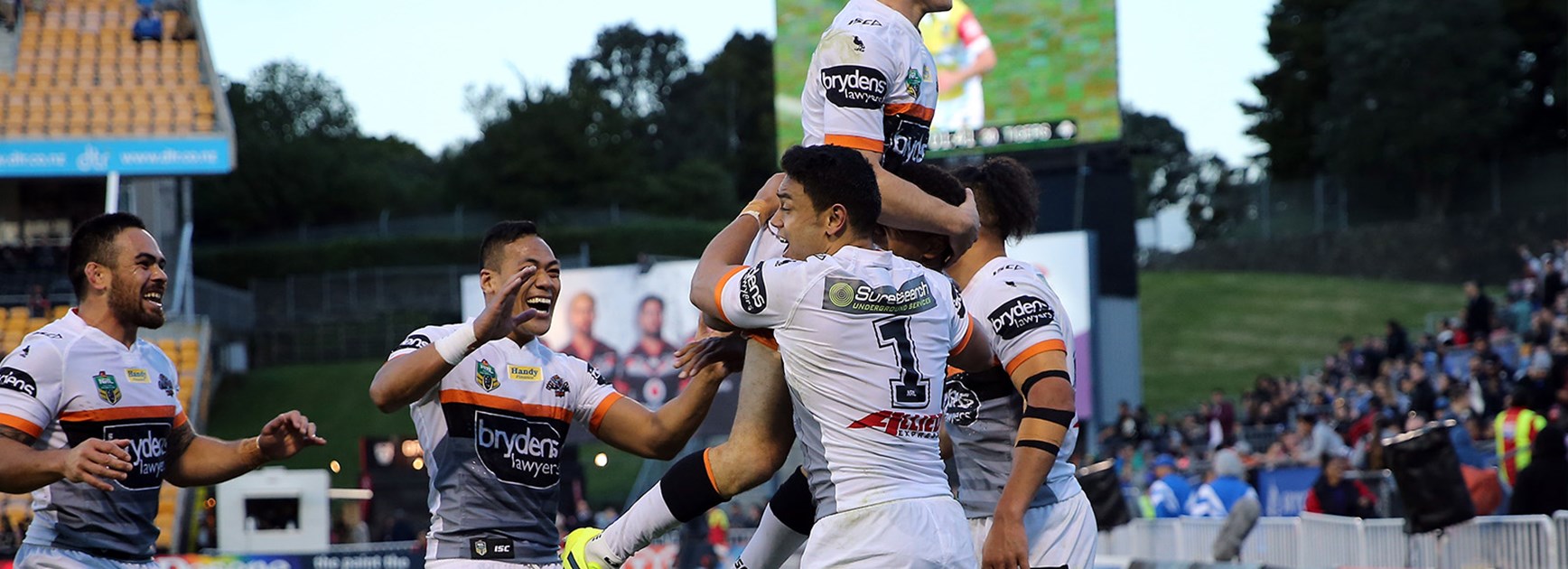 Mitch Moses celebrates with Wests Tigers teammates after a dramatic victory against the Warriors.