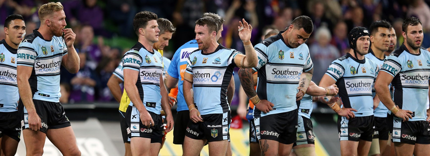 Sharks players look on dejected in their Round 26 loss to the Storm.