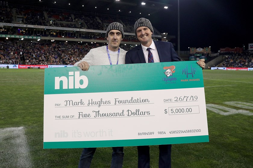 Mark Hughes accepts a cheque during Beanie For Brain Cancer Round.