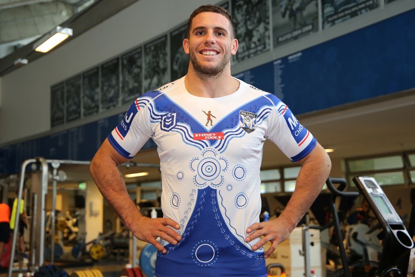 Adam Elliott models Canterbury's Indigenous Round jersey, designed by local Indigenous students from Bethlehem College, Ashfield.
The design of this year’s Jersey features traditional artwork by the Students, symbolising the coming together of our community for Indigenous Round.
Indigenous and Non-Indigenous players, Members of our community and the designers themselves are represented as Suns on the Jersey arranged around a meeting place – in this instance, our match against the Eels.
Also included on the Jersey are totem animals of the local area and the Cooks River, which has long enabled many tribes to come together.