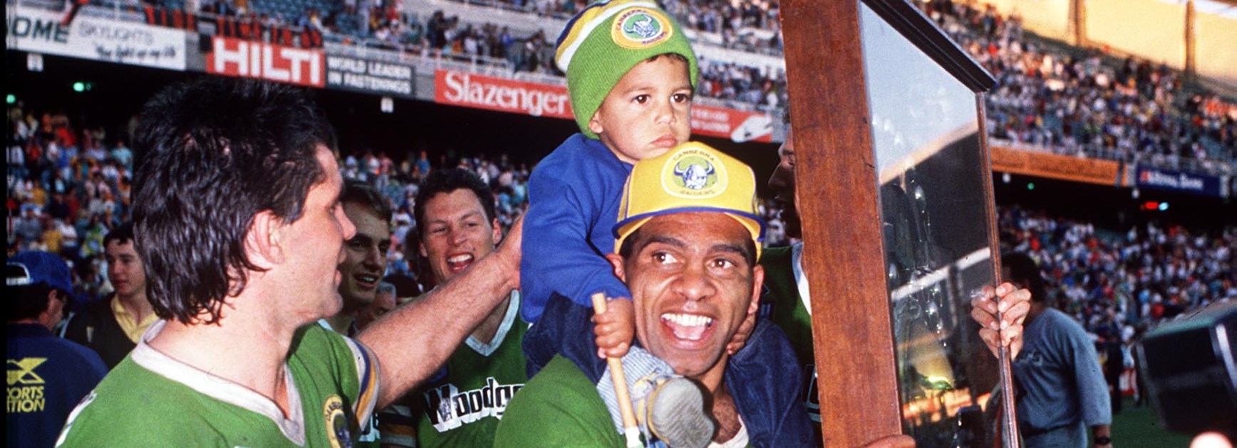 Raiders winger John Ferguson savours the spoils of victory with his son and five-eighth Chris O'Sullivan.