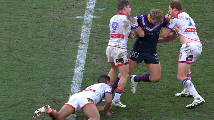 Melbourne's Christian Welch runs into contact with both arms wrapped firmly around the ball and is met firmly by Knights trio Connor Watson, Tim Glasby and Hymel Hunt. Glasby grabs Welch's left arm while Hunt drops to make a legs tackle and Watson wraps both arms around the ball and begins tugging it away. Watson can be seen giving Glasby a direction then reefing the ball out as Glasby releases Welch. 