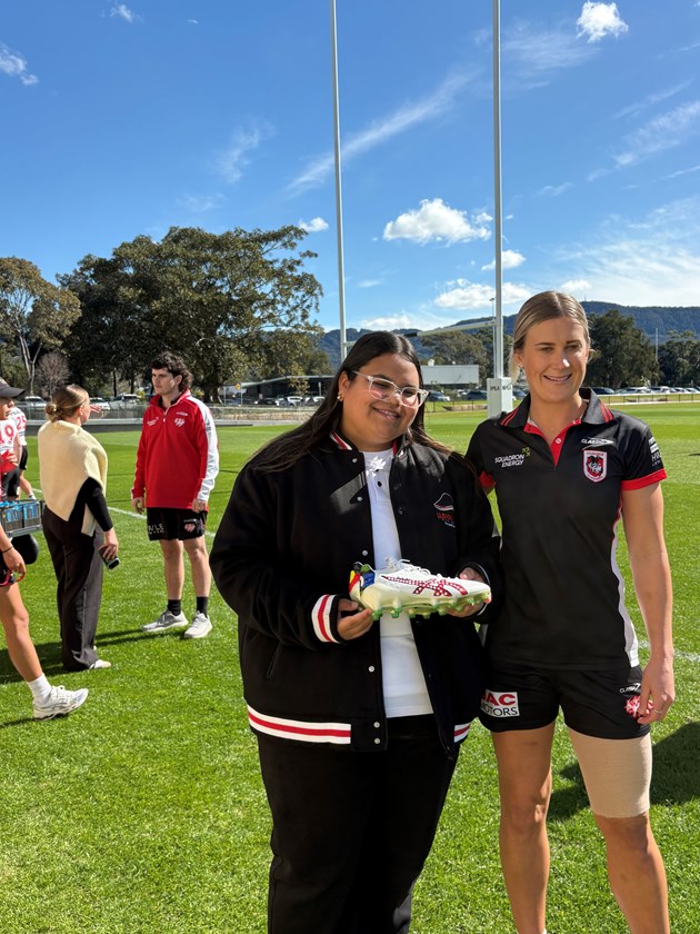 Shenae Ciesiolka receives her custom boots from artist Takysha Patterson for Indigenous Round.