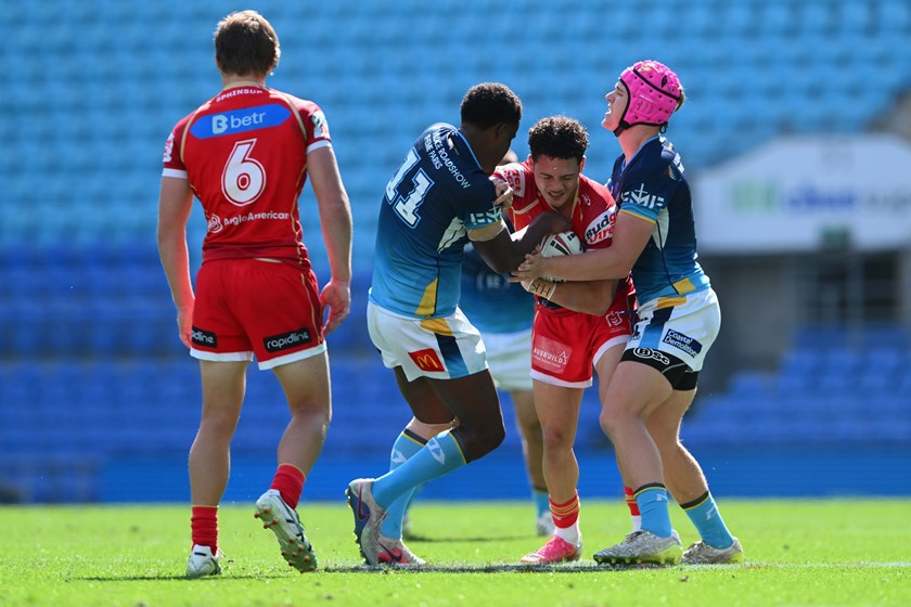 Adaquix-Jeramiah Watts-Luke is tackled by Titans defenders in their NRLQ match.