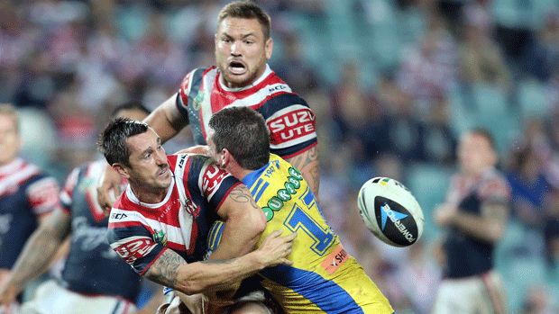 Jared Waerea-Hargreaves watches on as Eels prop Darcy Lussick makes a more conventional tackle on Roosters teammate Mitchell Pearce. Copyright: NRL Photos.