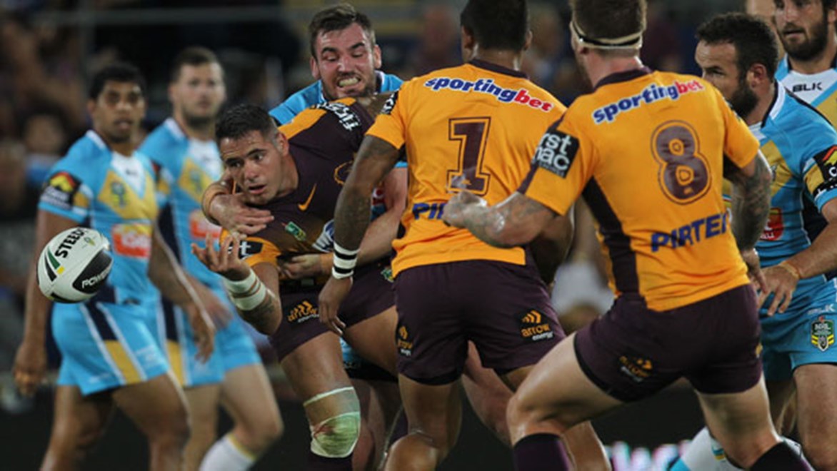 Broncos captain Corey Parker pops an offload despite the attention of Titans prop Luke Douglas during their clash on Friday night. Copyright: Col Whelan/NRL Photos