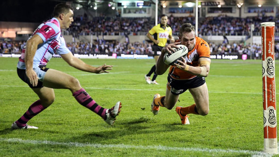 Wests Tigers winger Pat Richards dives over for a try in the first half of his side's clash against the Sharks on Saturday.