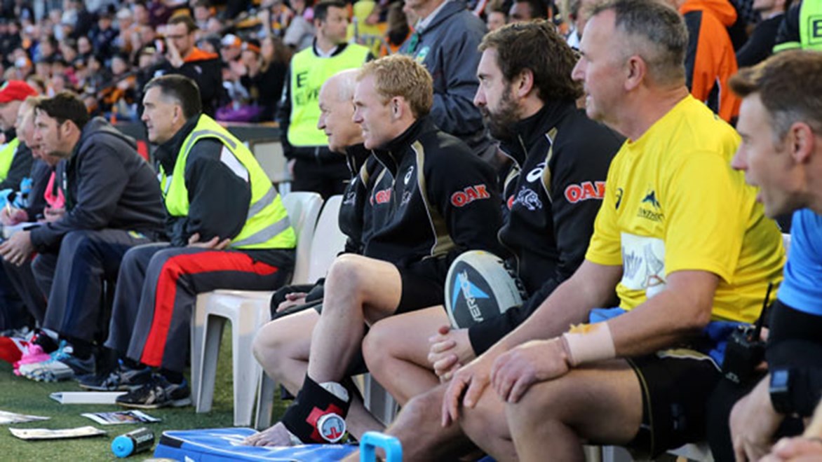 Injured Peter Wallace looks on from the sidelines as his team dismantles the Tigers at Leichhardt Oval.