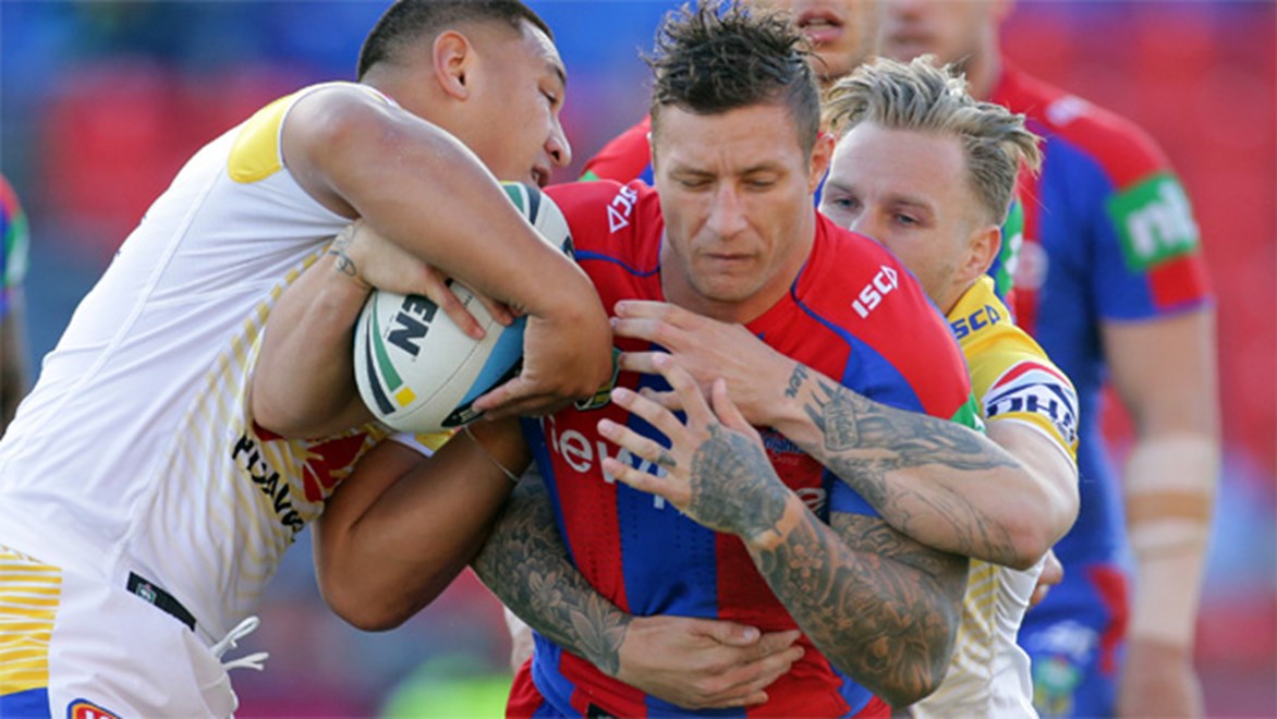 Knights forward Tariq Sims is wrapped up by the Canberra defence.