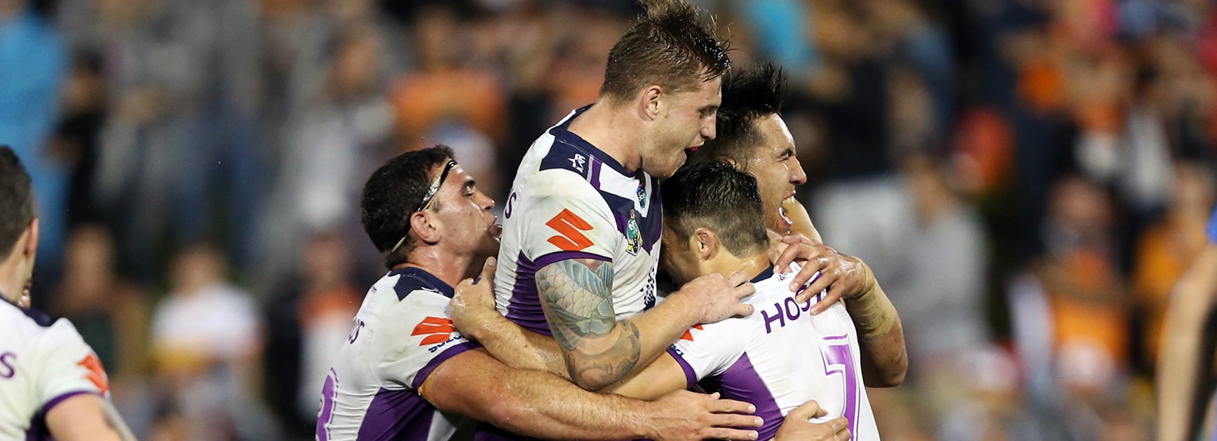 Storm players celebrate against Wests Tigers.