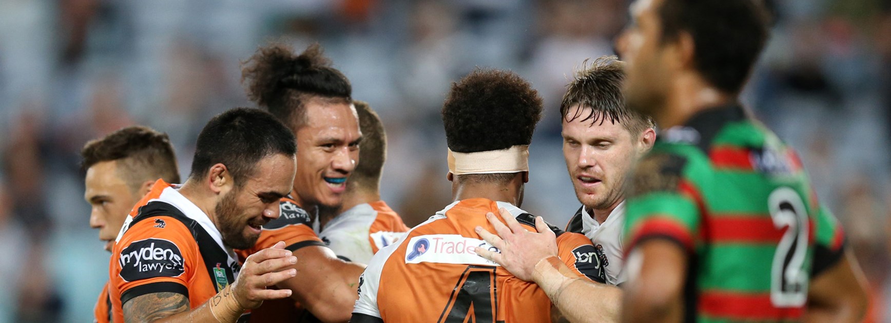 The Wests Tigers celebrate a first-half try against the Rabbitohs in Round 9.