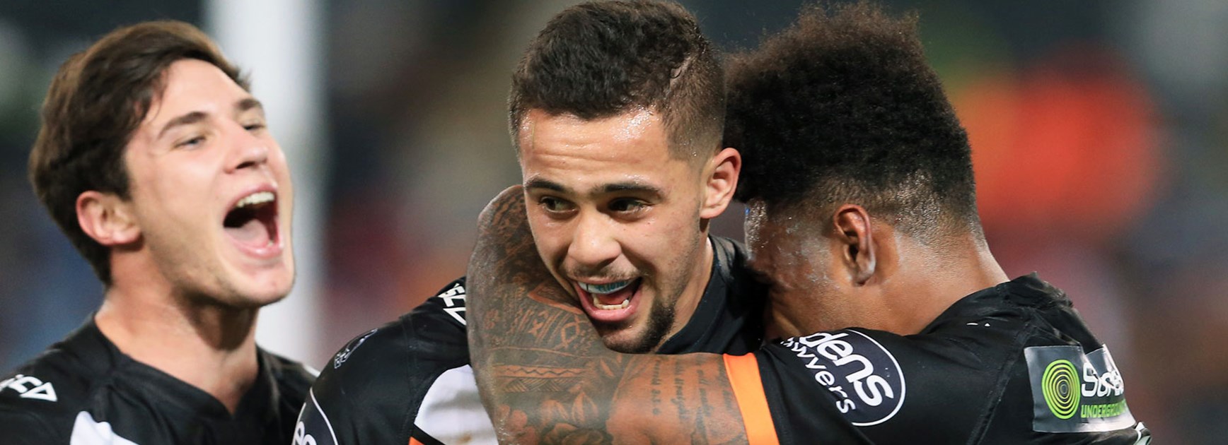 Wests Tigers back-rower Josh Aloiai celebrates a try with teammates.