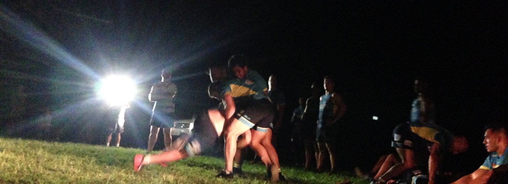 The Titans tackling under headlights during their training camp Coast at the Canungra Army Barracks.