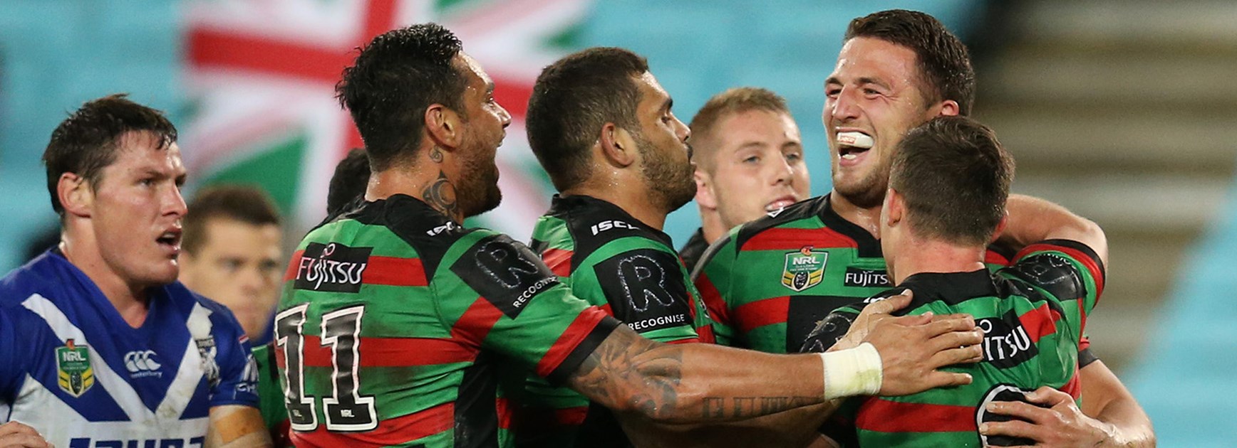 The Rabbitohs celebrate a try to Sam Burgess against the Bulldogs.