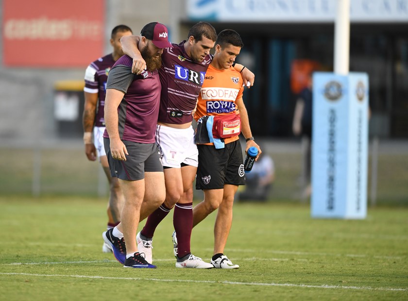 Manly prop Darcy Lussick is assisted from the field.