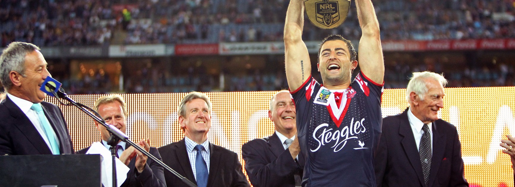 Roosters skipper Anthony Minichiello raises the premiership trophy in 2013.