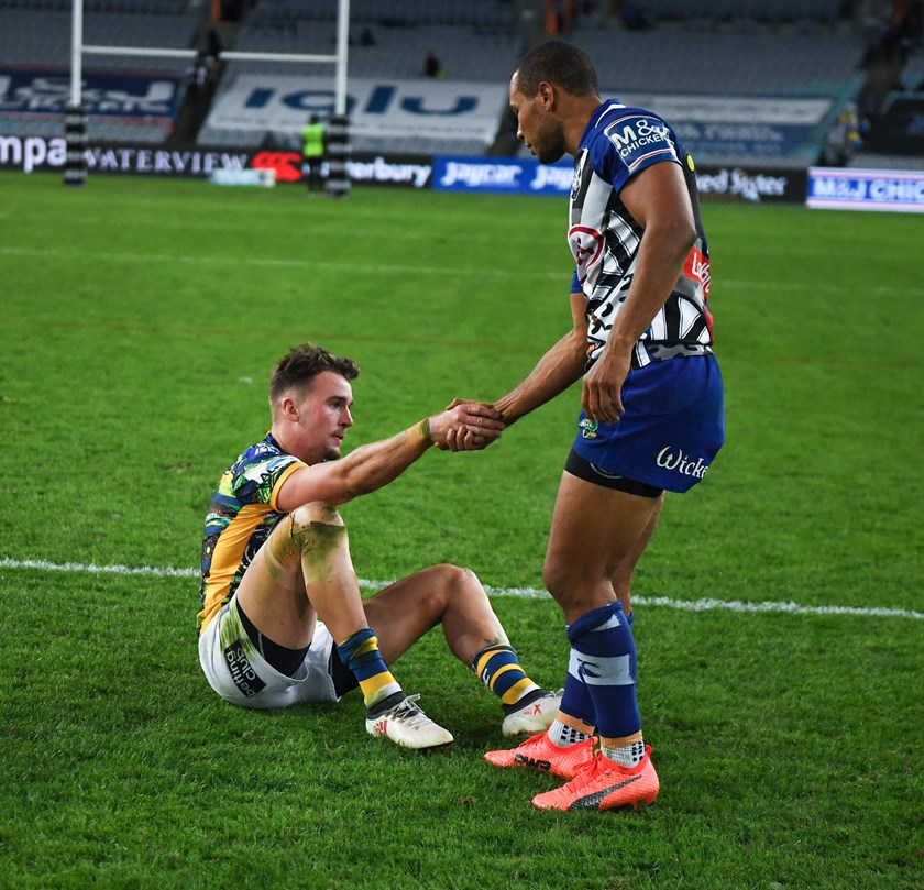 Bulldogs fullback Moses Mbye offers a hand to Eels fullback Clint Gutherson.