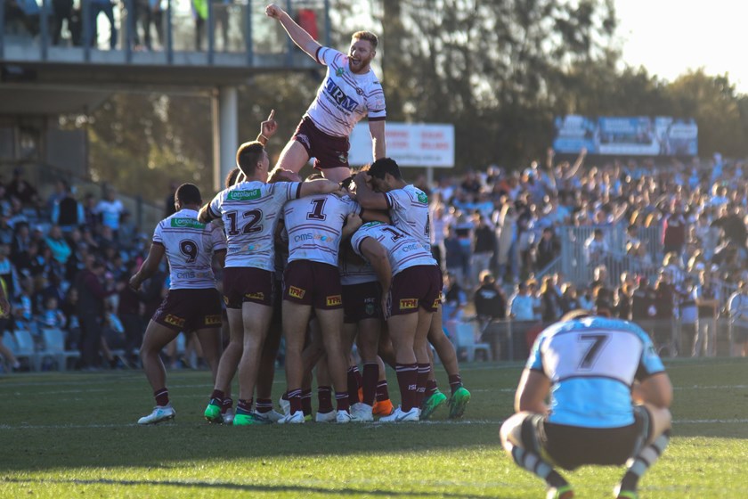 Brad Parker celebrates on top of Manly's huddle after beating Cronulla.
