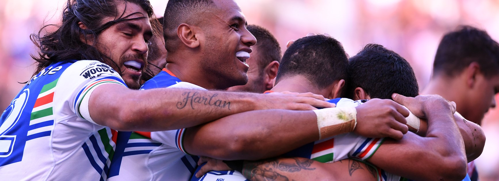 Warriors celebrate a try against the Roosters.