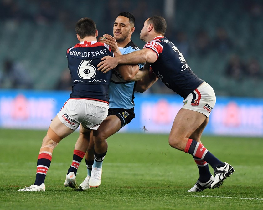 Sharks fullback Valentine Holmes is wrapped up by the Roosters defence.