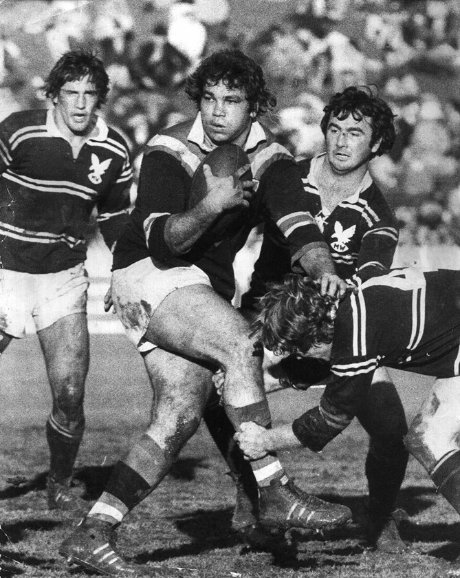 Roosters Immortal Arthur Beetson takes on Manly in 1975 as Terry Randall and Max Krilich look on.