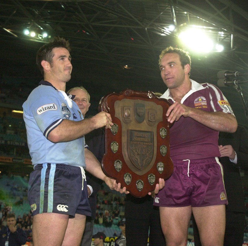 Rival captains Andrew Johns and Gorden Tallis look bemused holding up the Origin shield after game three in 2002.