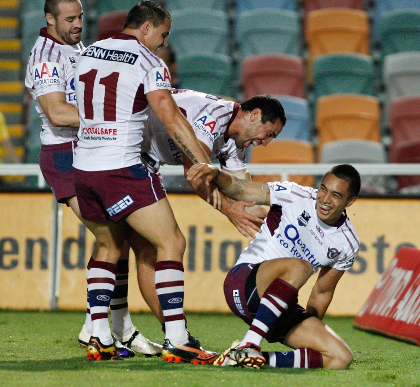 Dean Whare is swamped by Manly teammates after scoring in his NRL debut against the Cowboys.