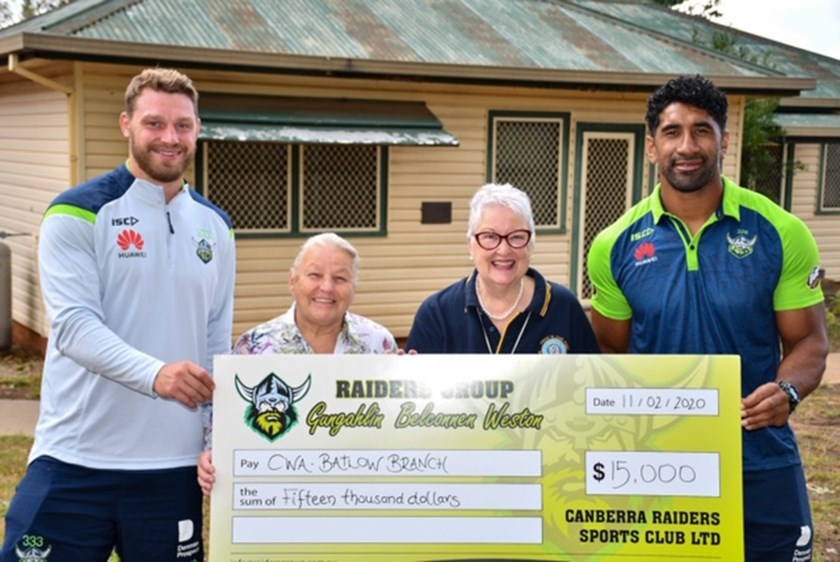 Elliott Whitehead and Sia Soliola present a cheque to the Batlow Country Women's Association.