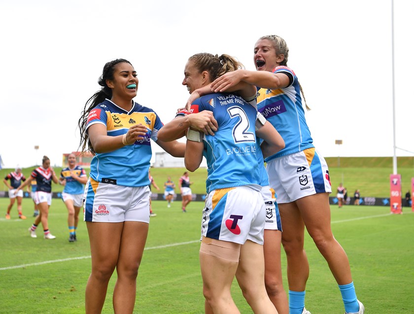 Karina Brown is swamped by her Titans team-mates after scoring  a try in the club's first ever win.