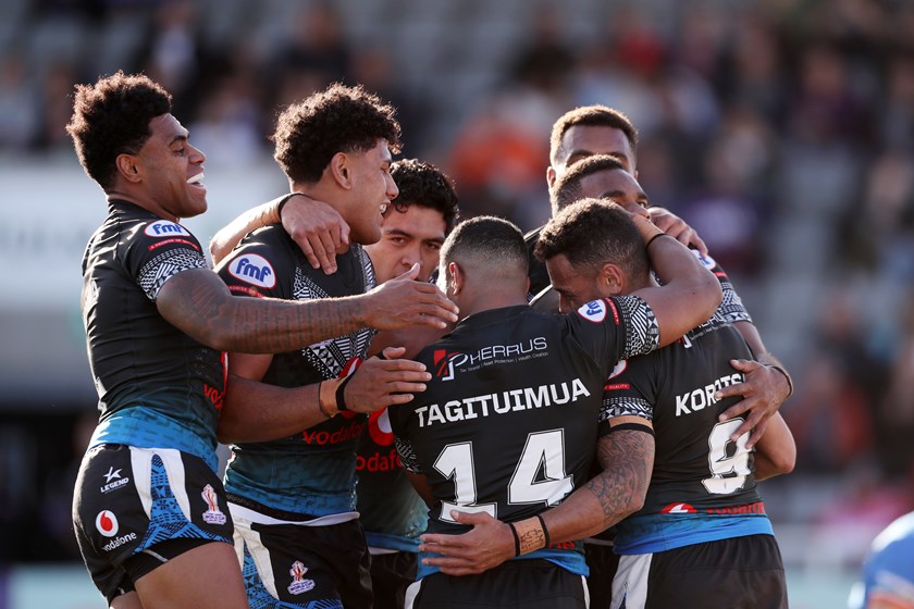 Penioni Tagituimua is mobbed by teammates after his second try.