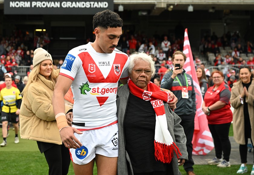 Tyrell Sloan walks onto the field with his grandmother Colleen during Women in League round last year.