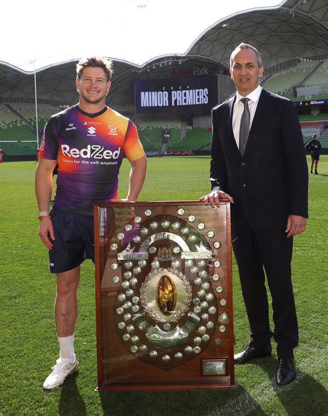 NRL CEO Andrew Abdo presents the JJ Giltinan Shield to Storm captain Harry Grant.