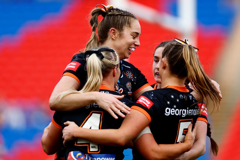 Kezie Apps celebrates with Wests Tigers team-mates after an Emily Bass try against the Knights.