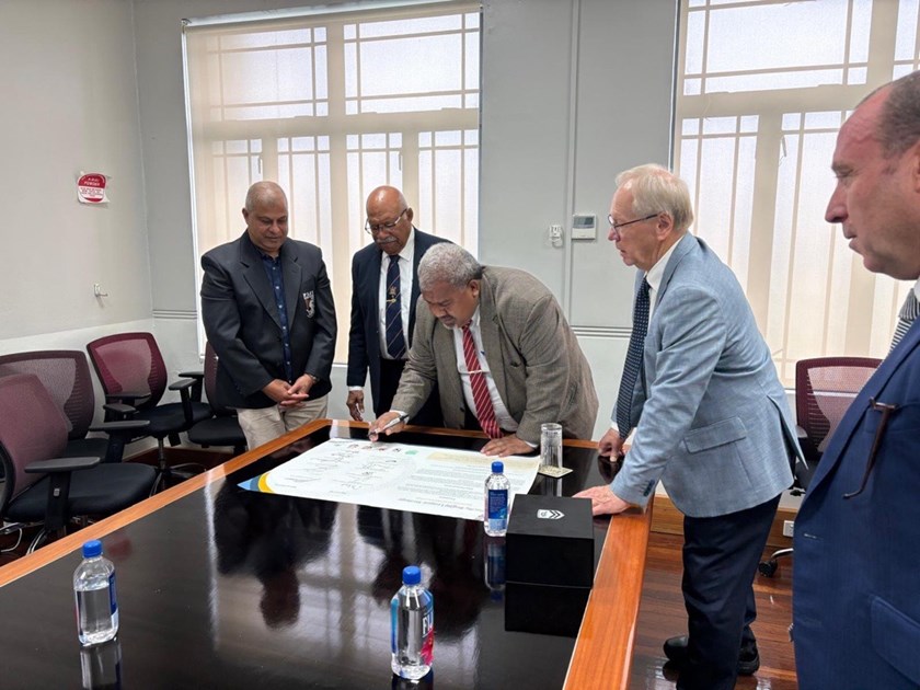 Fiji Prime Minister Sitiveni Rabuka and ARL Commissioner Peter Beatie look as Minister for Youth and Sports Jese Saukuru signs the Pacific Rugby League Partnership.