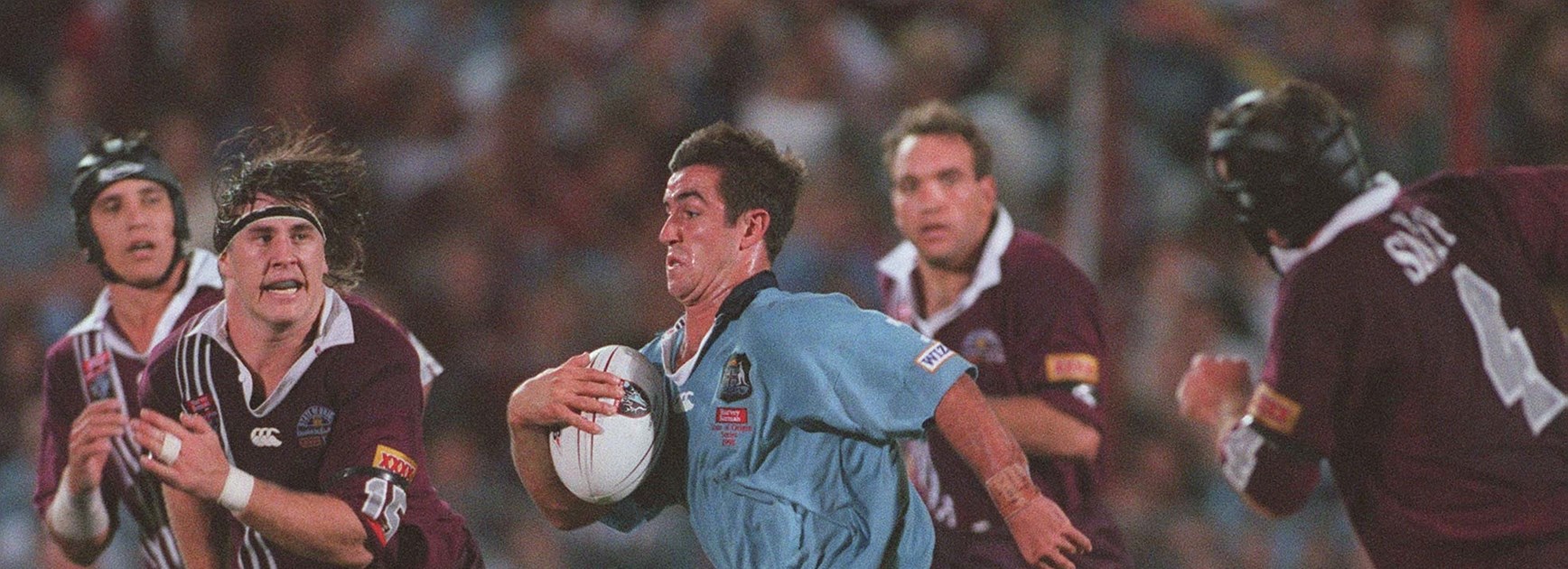 Johns attempts to speed away from Queensland front-rower Martin Lang in 1999.